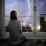 The,Girl,Looks,Through,The,Window,At,The,Lightning.,Thunderstorm